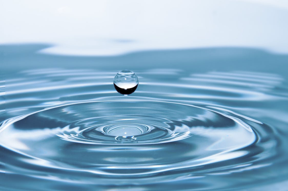 Water droplet creating rings in water. 