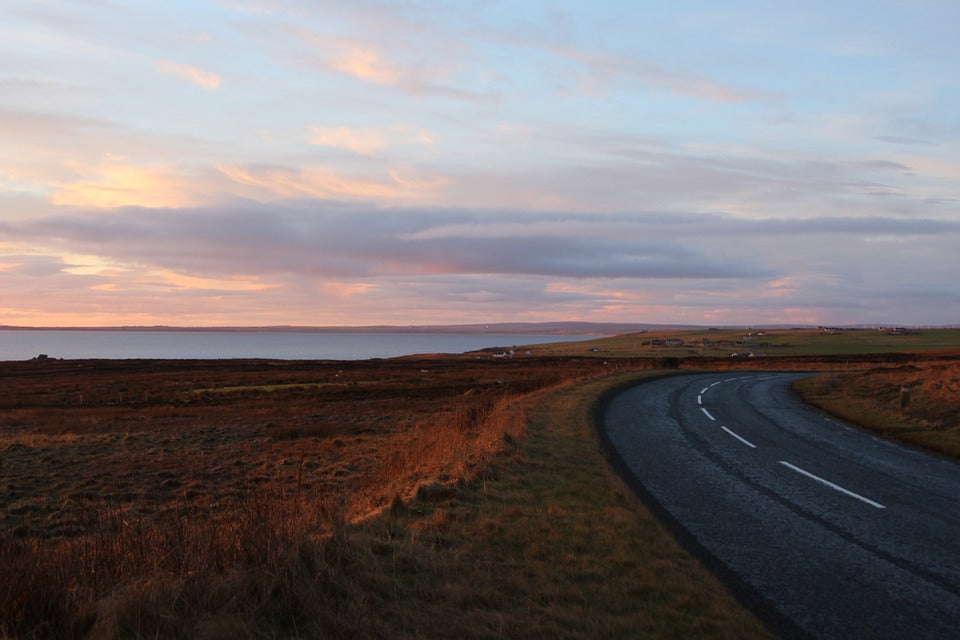 A road by the coastline in John O’ groats, Scotland, at sunset