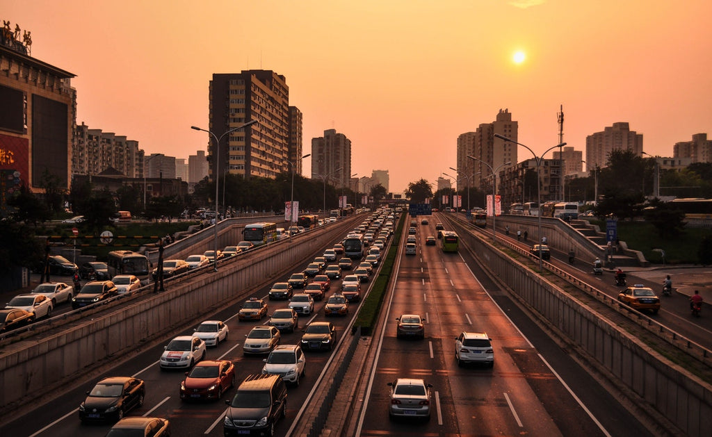 View of busy road in the sunset surrounded by buildings. 