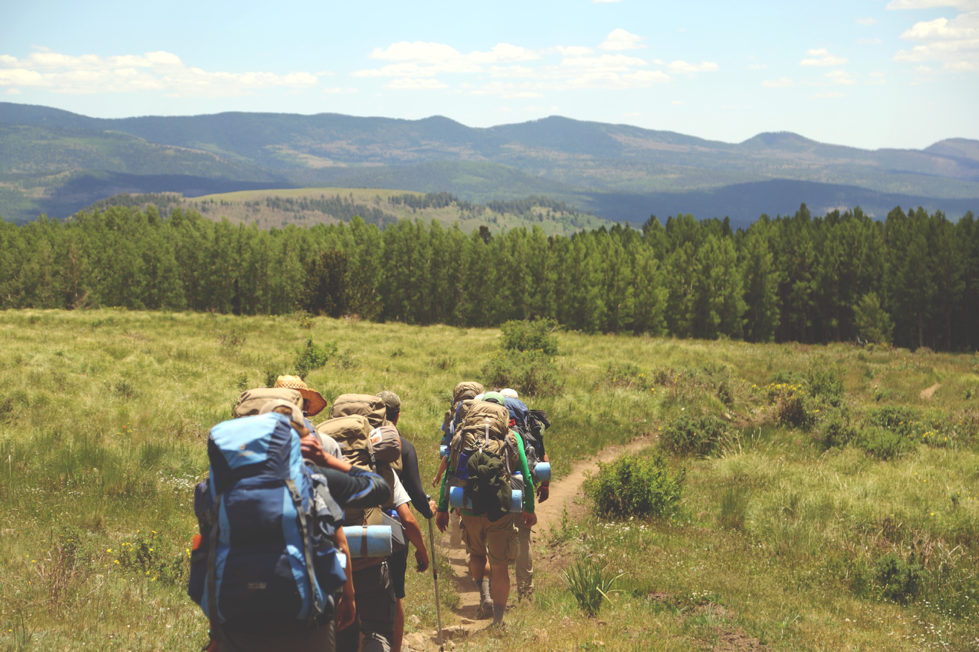 Backpackers walking through a field