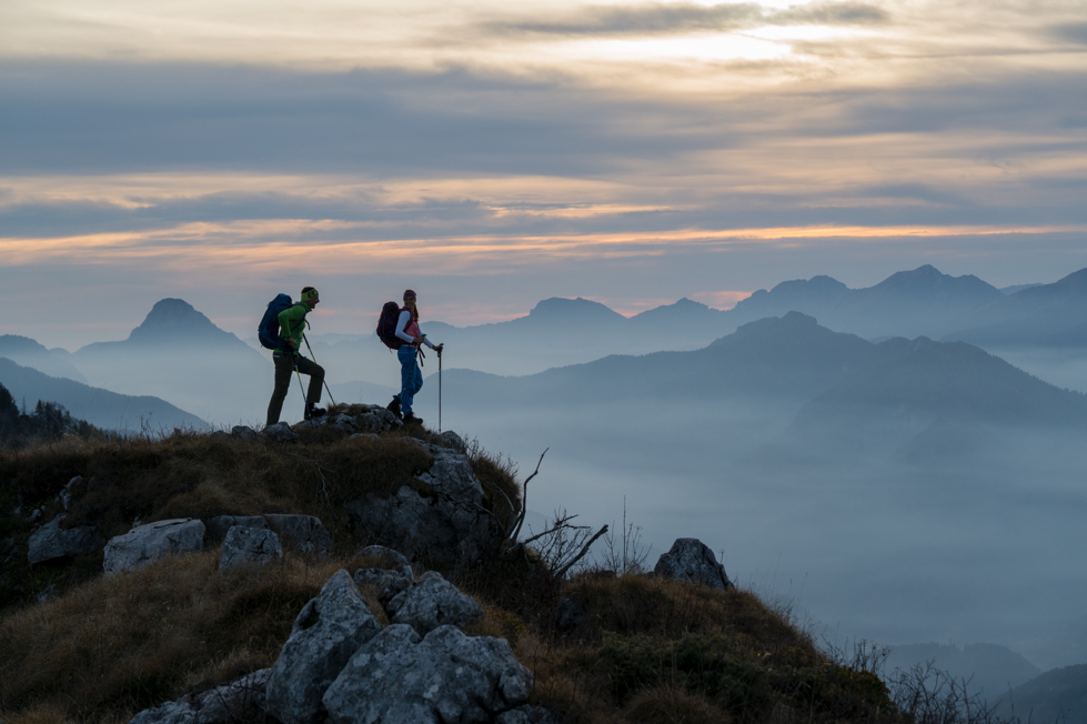 Two people at the top of a mountain wearing LOWA boots at dusk