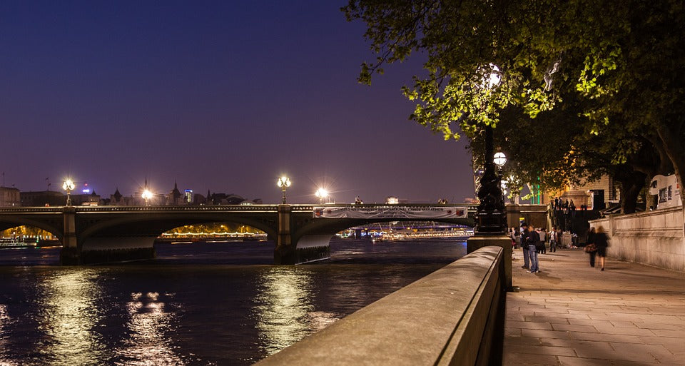 An urban walkway by the River Thames in London at night