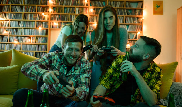 Jóvenes amigos jugando videojuegos frente a pantalla con luz azul en sus rostros