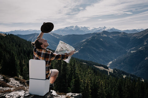 man sitting on composting toilet in the mountains