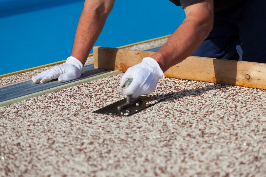 application de granulat sur une terrasse de piscine