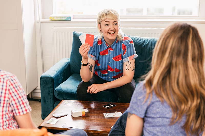 1 player helping another by pointing to a deck of cards