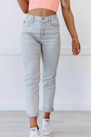 A model is wearing and posing in light grey Kancan Valentina Pinstripe Mom Jeans from York & Dante