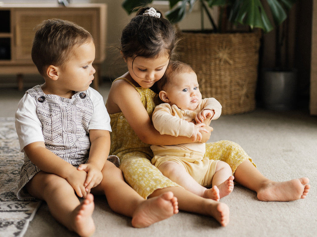 Three bilingual siblings sitting in living room
