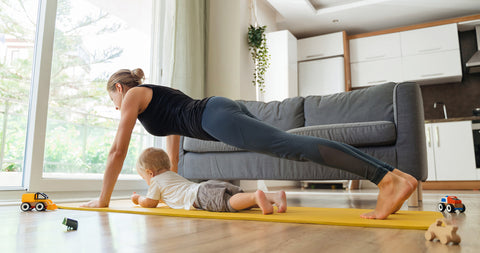 woman doing plank exercise with baby