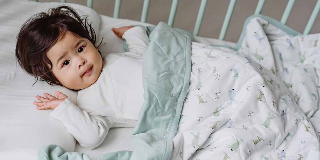 Baby under Nest Designs' quilted blanket