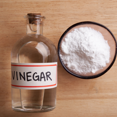 vinegar in a bottle and bowl of flour side by side