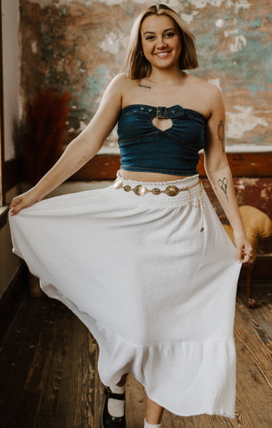 Person twirling their white skirt wearing silver fidget jewelry