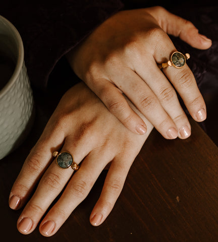 Person with their hands crossed. Both hands are wearing a Fisheye Agate Crystal Fidget Ring.