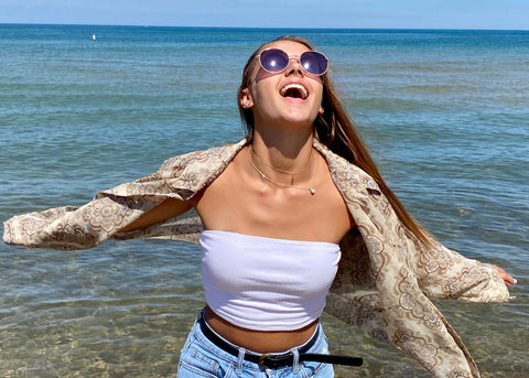 Person in front of the ocean smiling