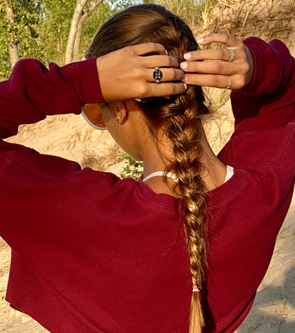 Person playing with hair and wearing fidget jewelry