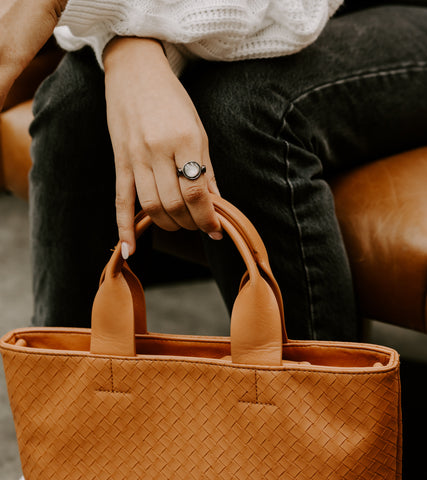 Person holding purse wearing Gray Shell fidget ring