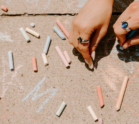 Two people coloring with chalk wearing fidget rings