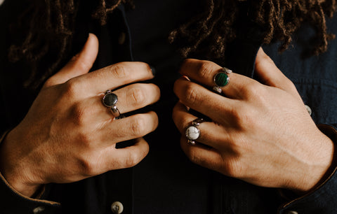 Person holding their jacket wearing a Howlite crystal fidget spinner.