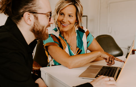 CONQUERing founders looking at plans on laptop together