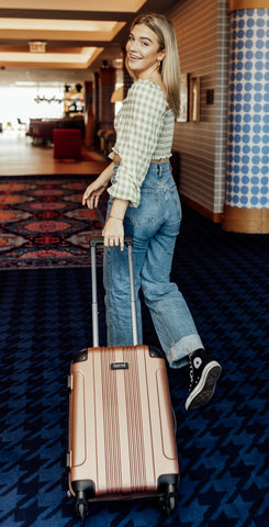 Person holding a suitcase wearing fidget rings