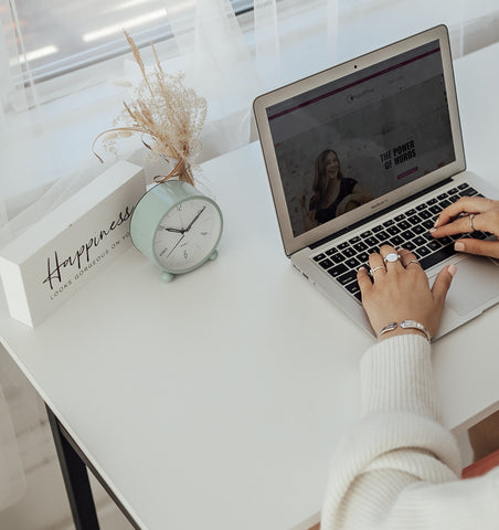 Person typing on laptop wearing fidget jewelry