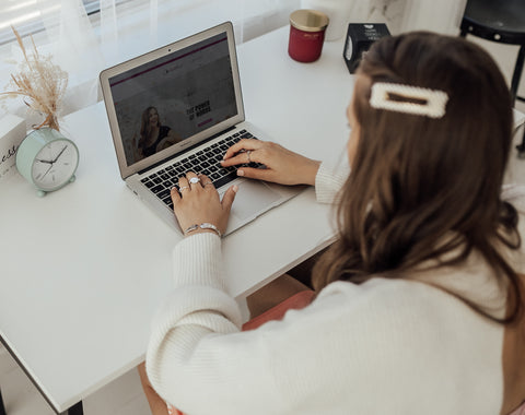 Person typing on a computer wearing a silver fidget ring