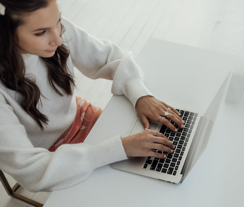 Person typing on laptop wearing silver fidget ring