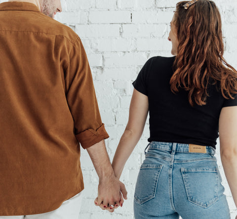 Two friends holding hands wearing fidget jewelry