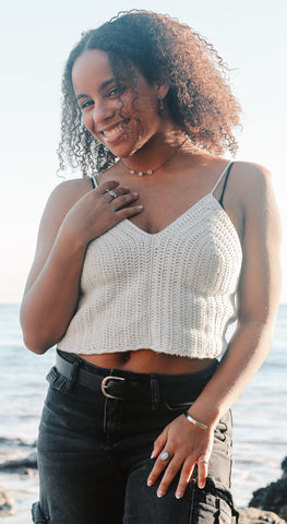 Person in front of the ocean wearing fidget ring made out of moonstone