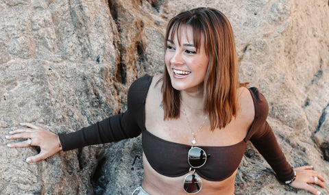 Person sitting on rock, smiling, and wearing silver fidget ring