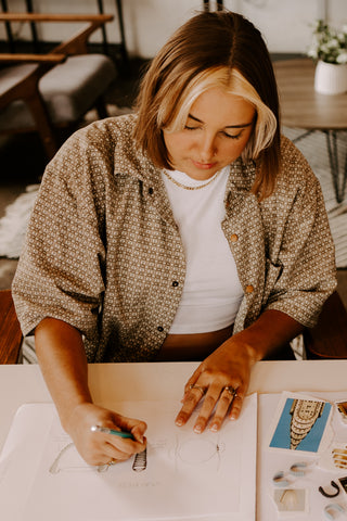 Person sketching a design wearing fidget rings