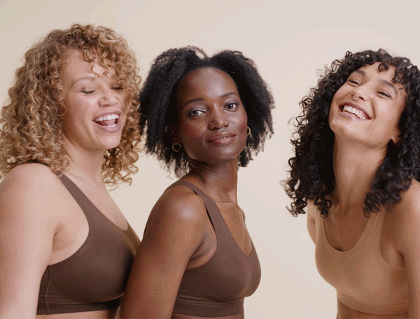 three women with curly hair dancing