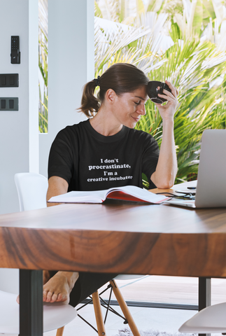 image of lady wearing "I don't procrastinate, I'm a creative incubator" organic graphic t-shirt"
