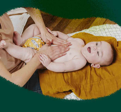 Una madre da un masaje a su bebé en la barriga 
