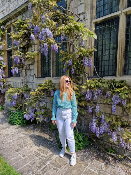 a girl standing in front of a wisteria
