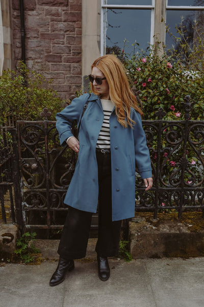 a girl wearing a blue vintage trench coat in edinburgh