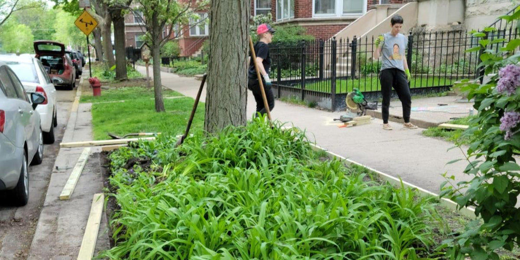 Two people on a break from installing landscape edging in the parkway in front of their home