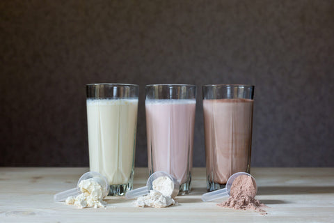 strawberry, chocolate and vanilla protein shake in a line