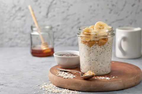 protein overnight oats in jars on a wooden cutting board