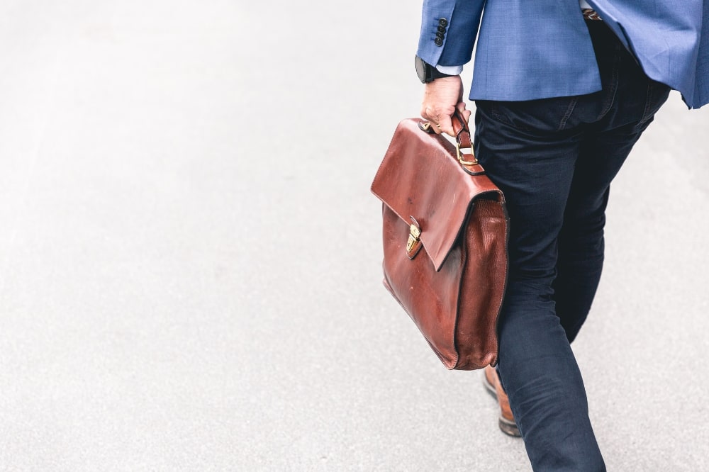 通勤にブラウンのビジネスバッグを使うビジネスマンの写真