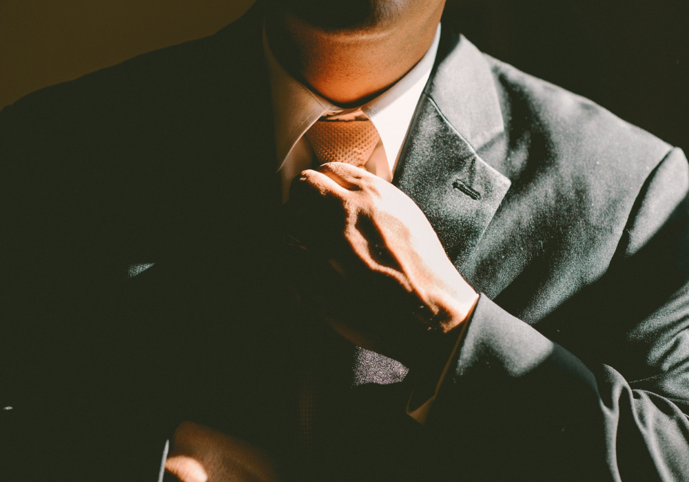 ネクタイを正すビジネスマンの写真