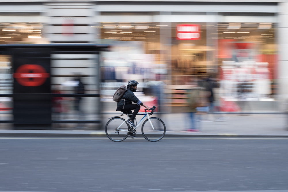 リュックを背負った人が自転車で走っている画像