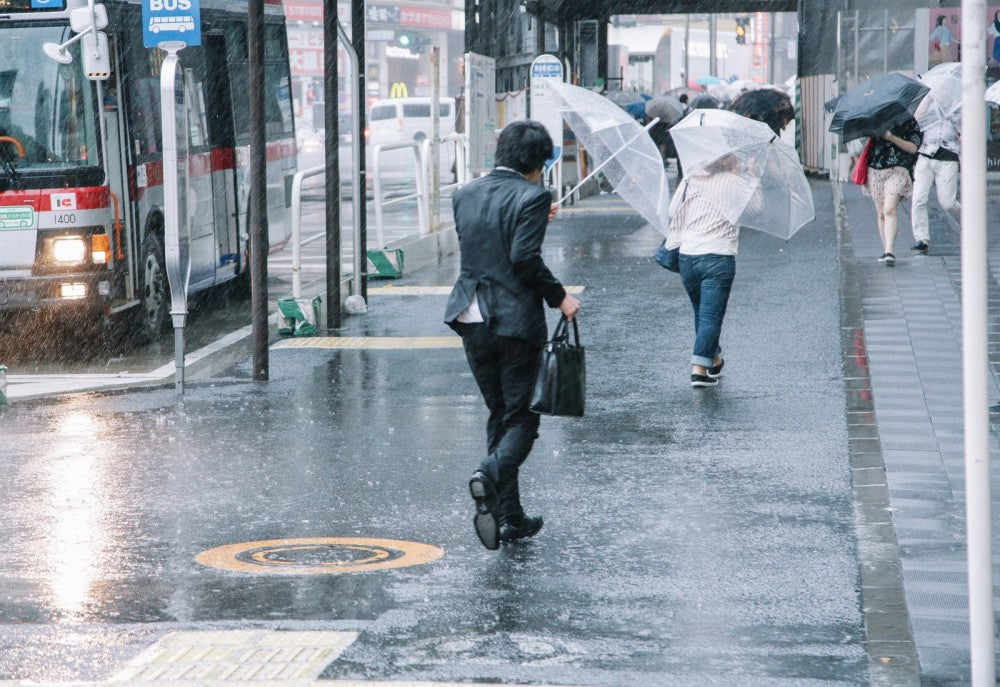ひどい雨でびしょ濡れのビジネスマンの写真