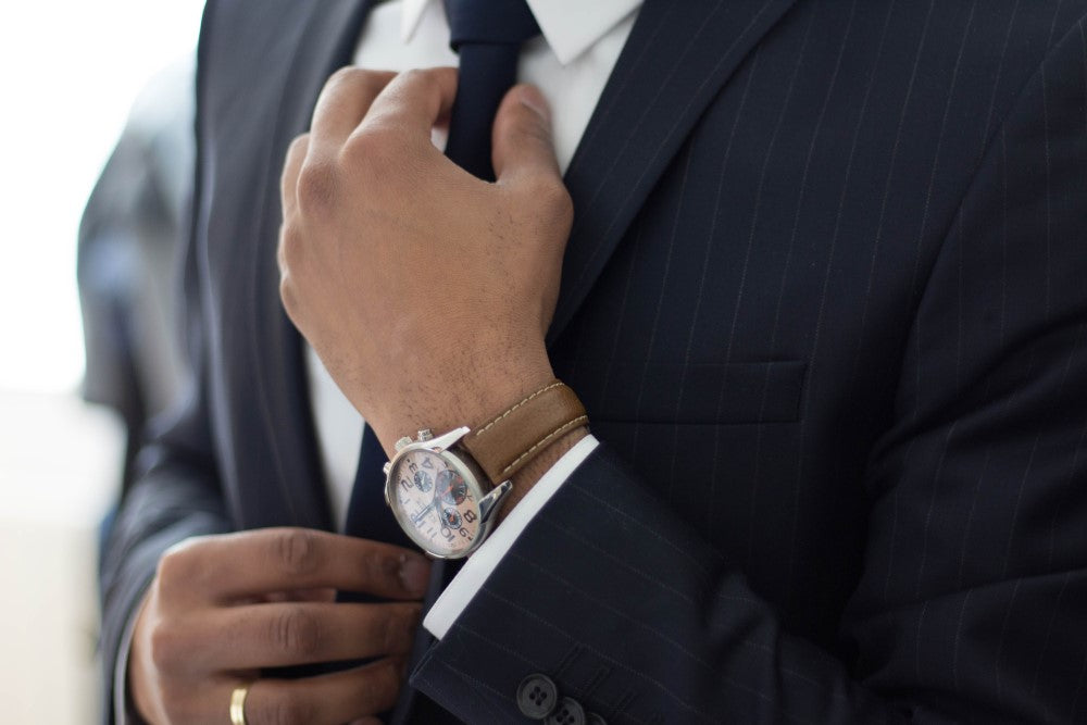 ビジネスマンがスーツのネクタイを触っている画像