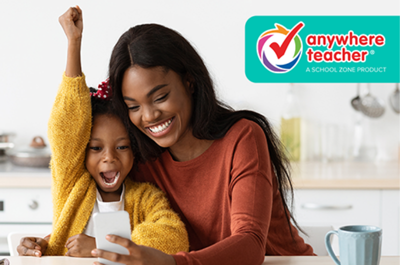 mother and daughter at the kitchen counter looking at her phone and the daughter has her arm in the air very excited