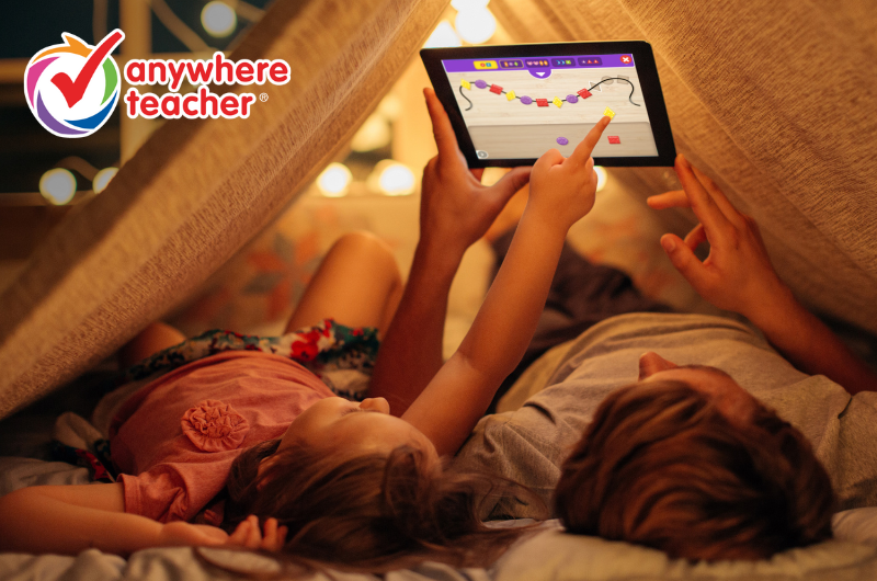 a father and young daughter in a tent playing a pattern making math game on a tablet