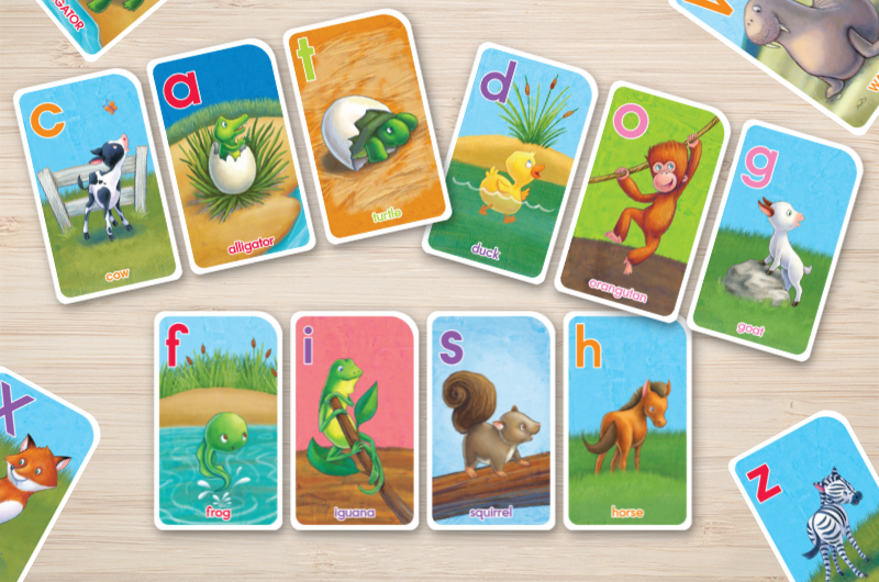 Go Fish alphabet game card layed out on a table to spell three words; cat, dog, and fish  