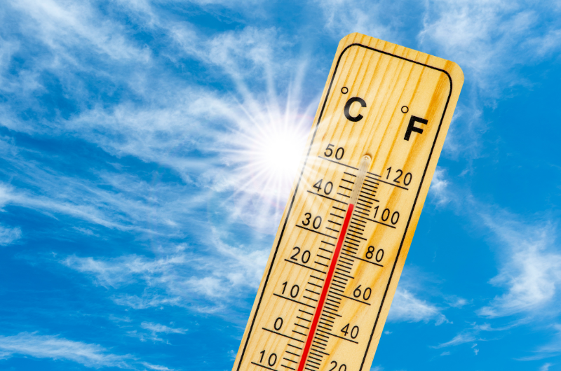 sunny blue sky with a close-up image of a thermometer showing over 100 degrees Fahrenheit 