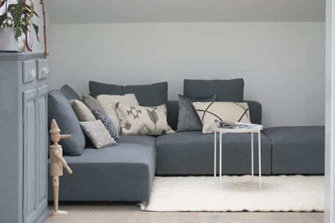 tappeto chiaro minimalista con divano grigio scuro moderno