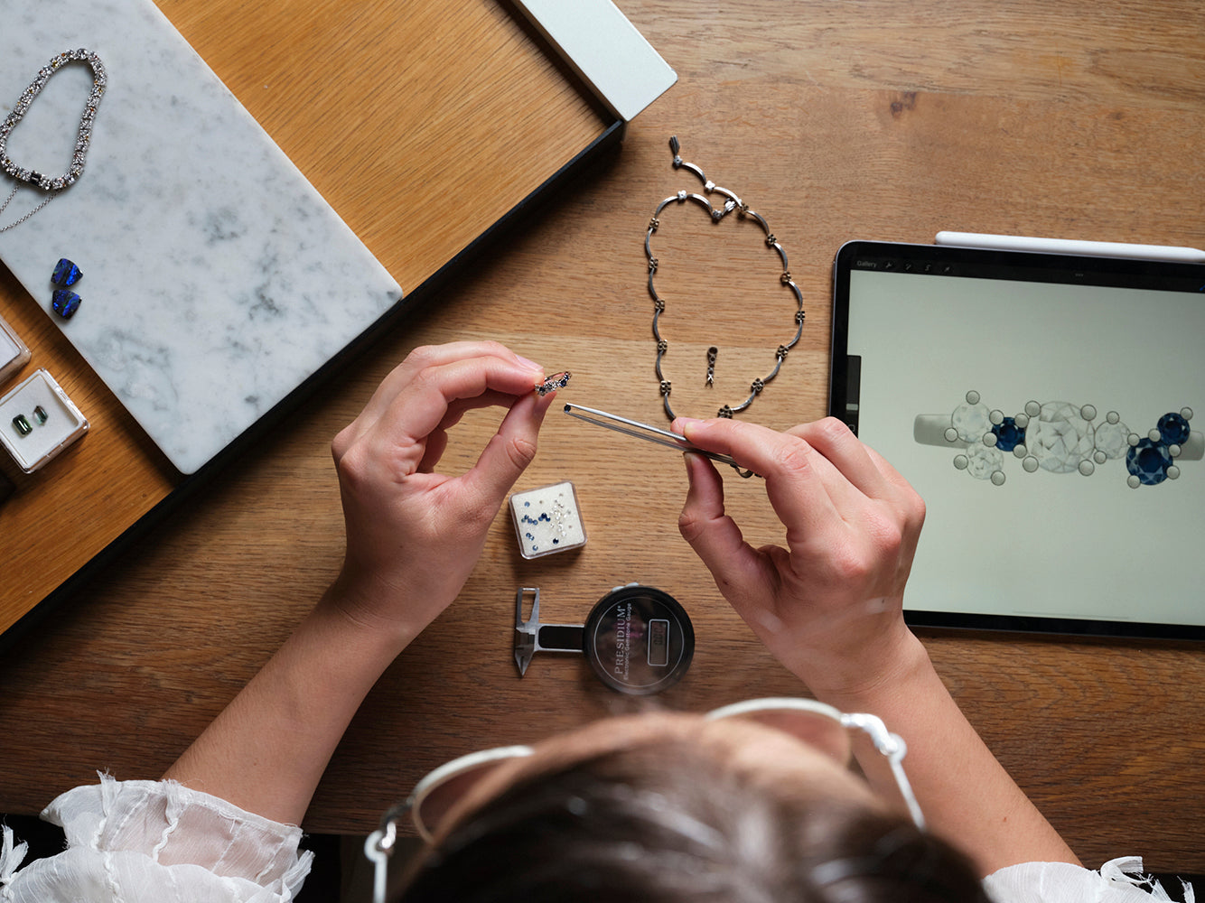 An artist places a gemstone in a ring